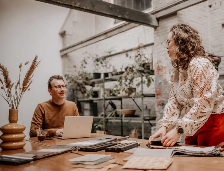 Personen, tafel, laptop, materiaalstalen, planten